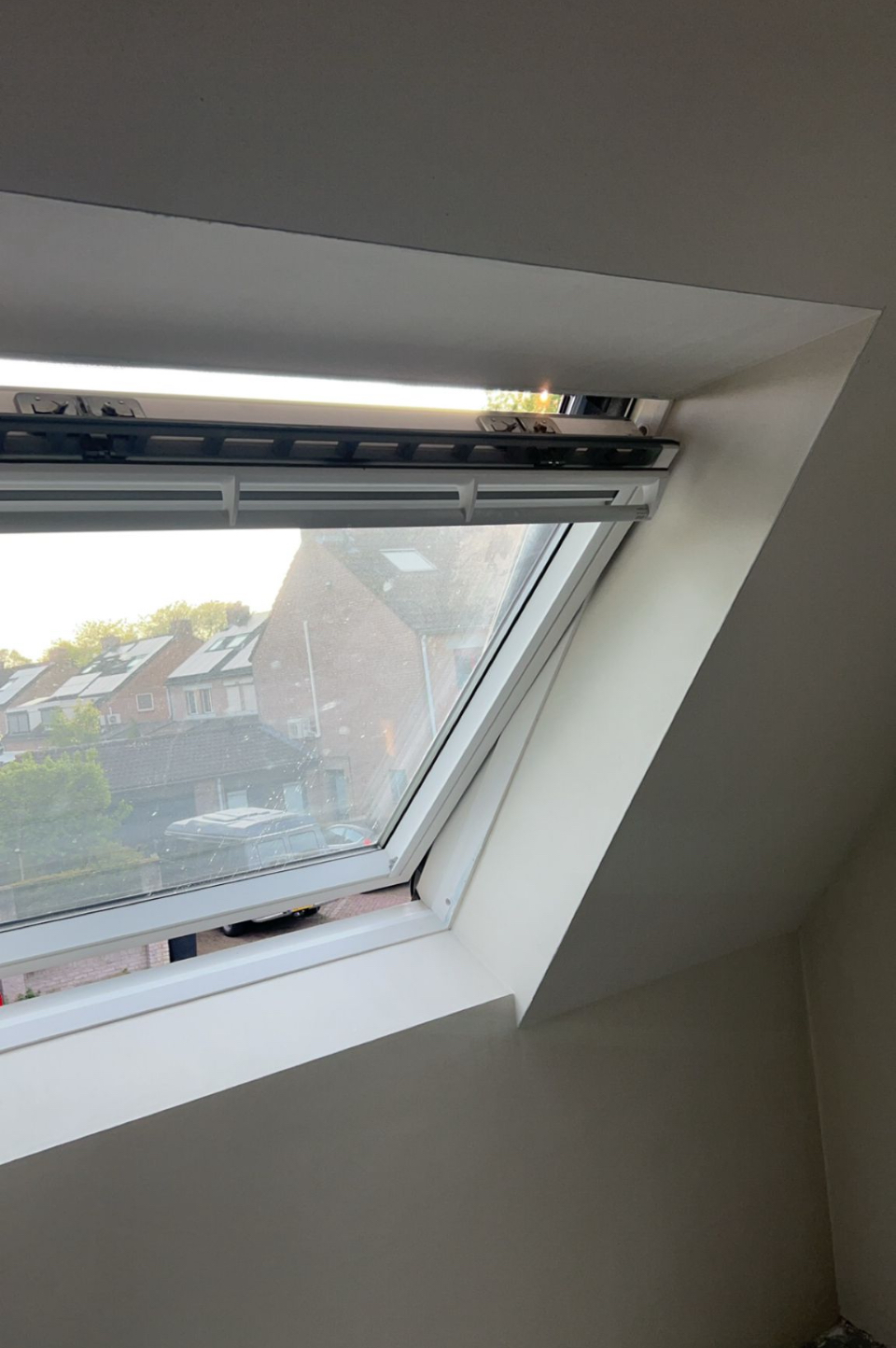 Strak gestucte dagkanten rond een dakraam in een schuin plafond