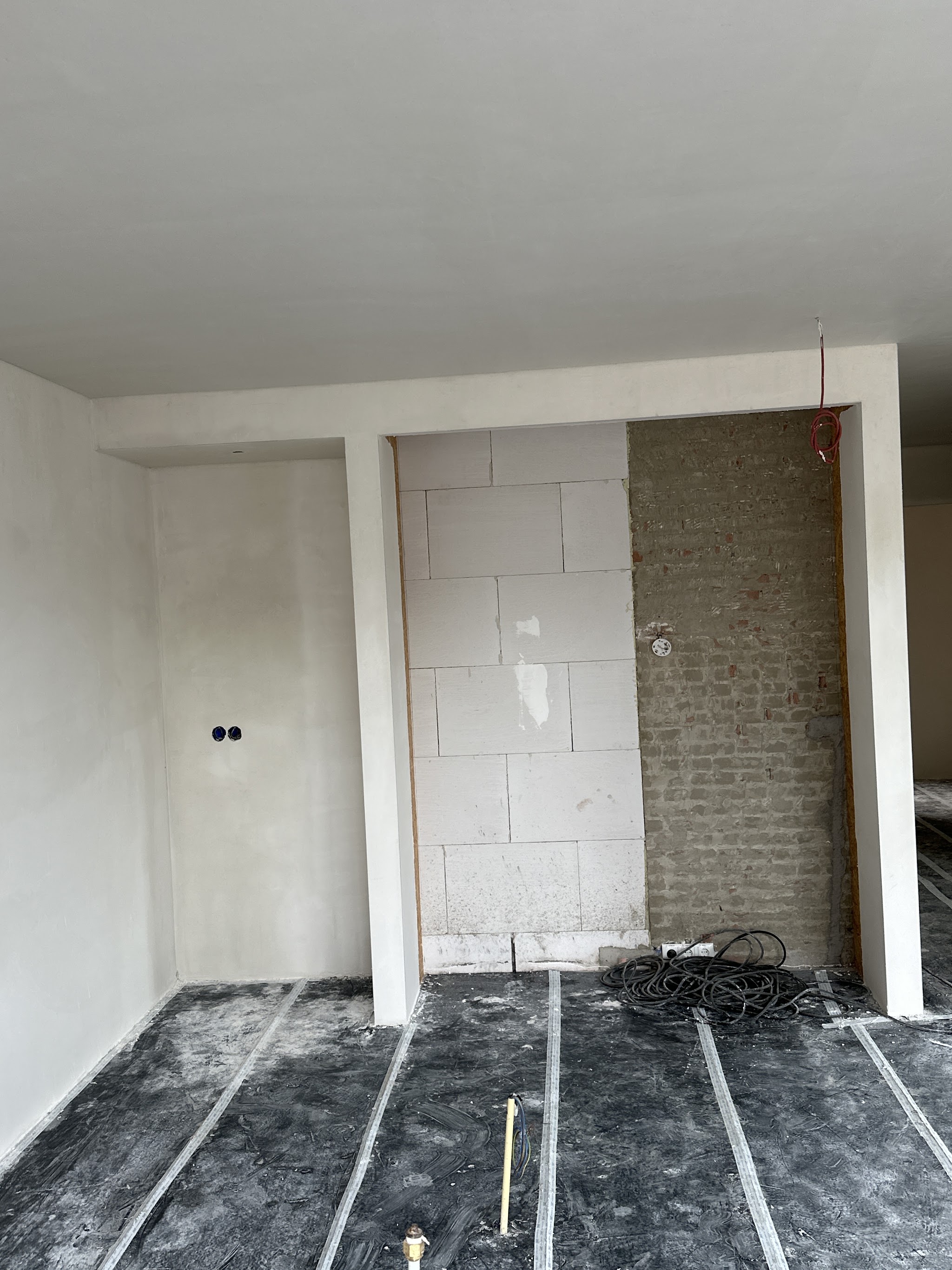 Benedenverdieping tijdens de klus, met gestucte wanden en de nis voor de keuken